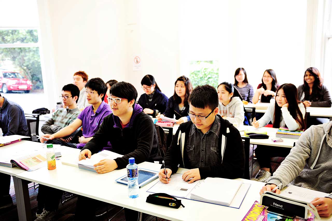 A class of INTO international students using textbooks and iPads to study