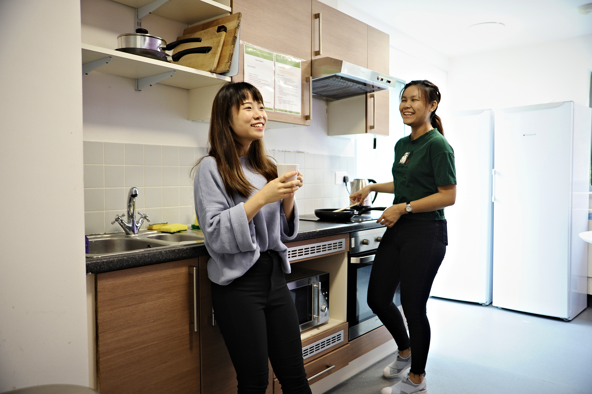 International students talking in shared kitchen in INTO University of Exeter student residences