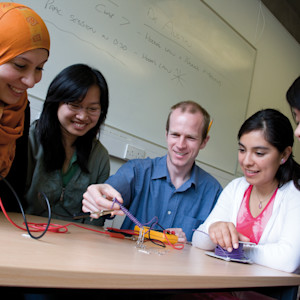 INTO Students and teacher with wires. INTO Students and teacher with wires.