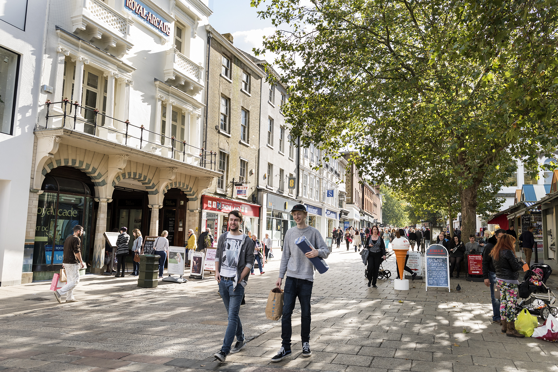 People walking along a street in Norwich during the day