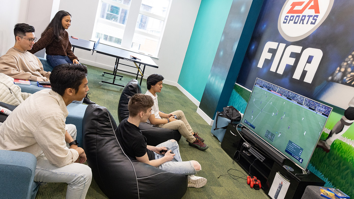 Students playing on a games console in the common room 