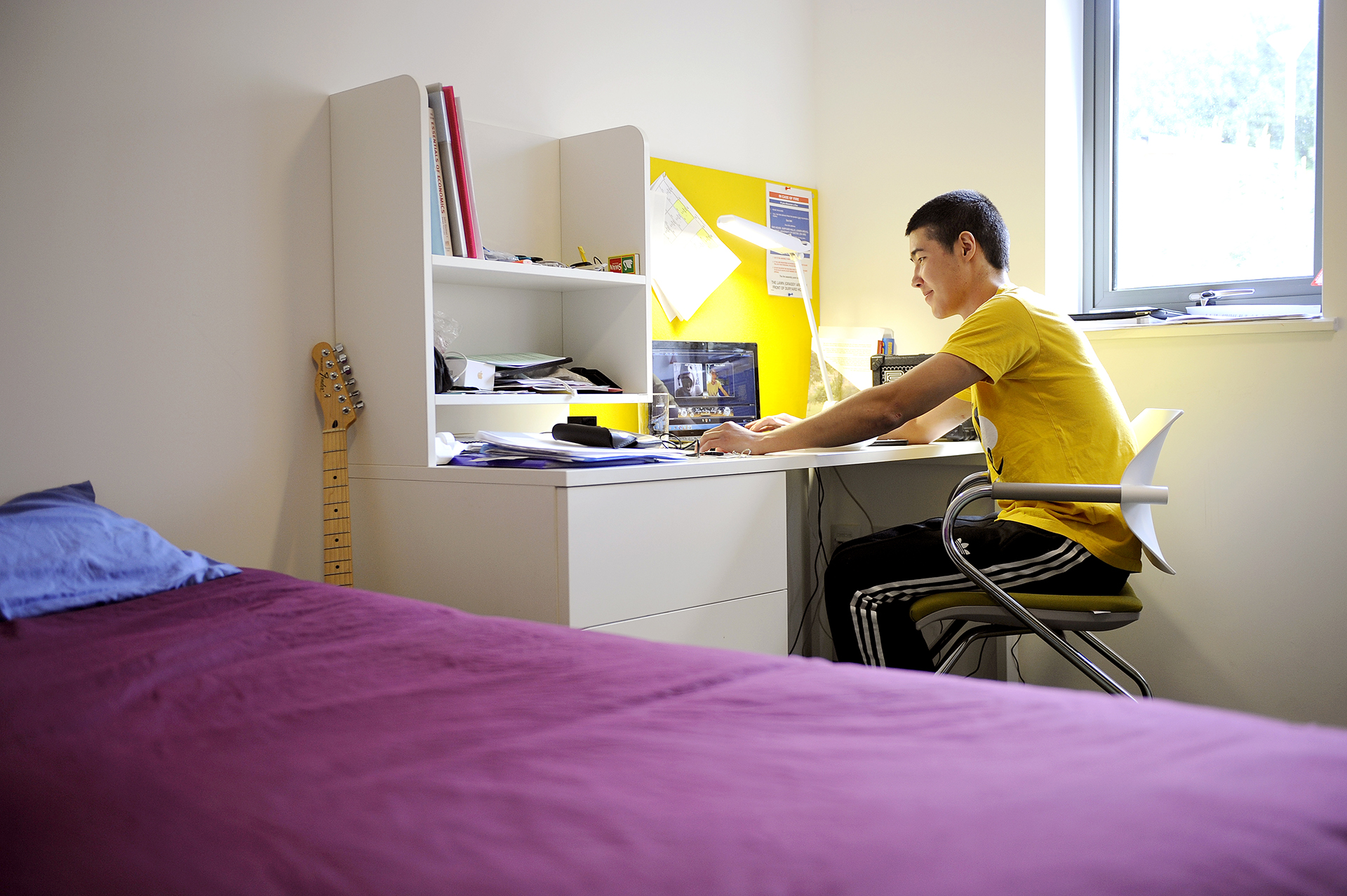 Student sitting in bedroom at INTO University of Exeter