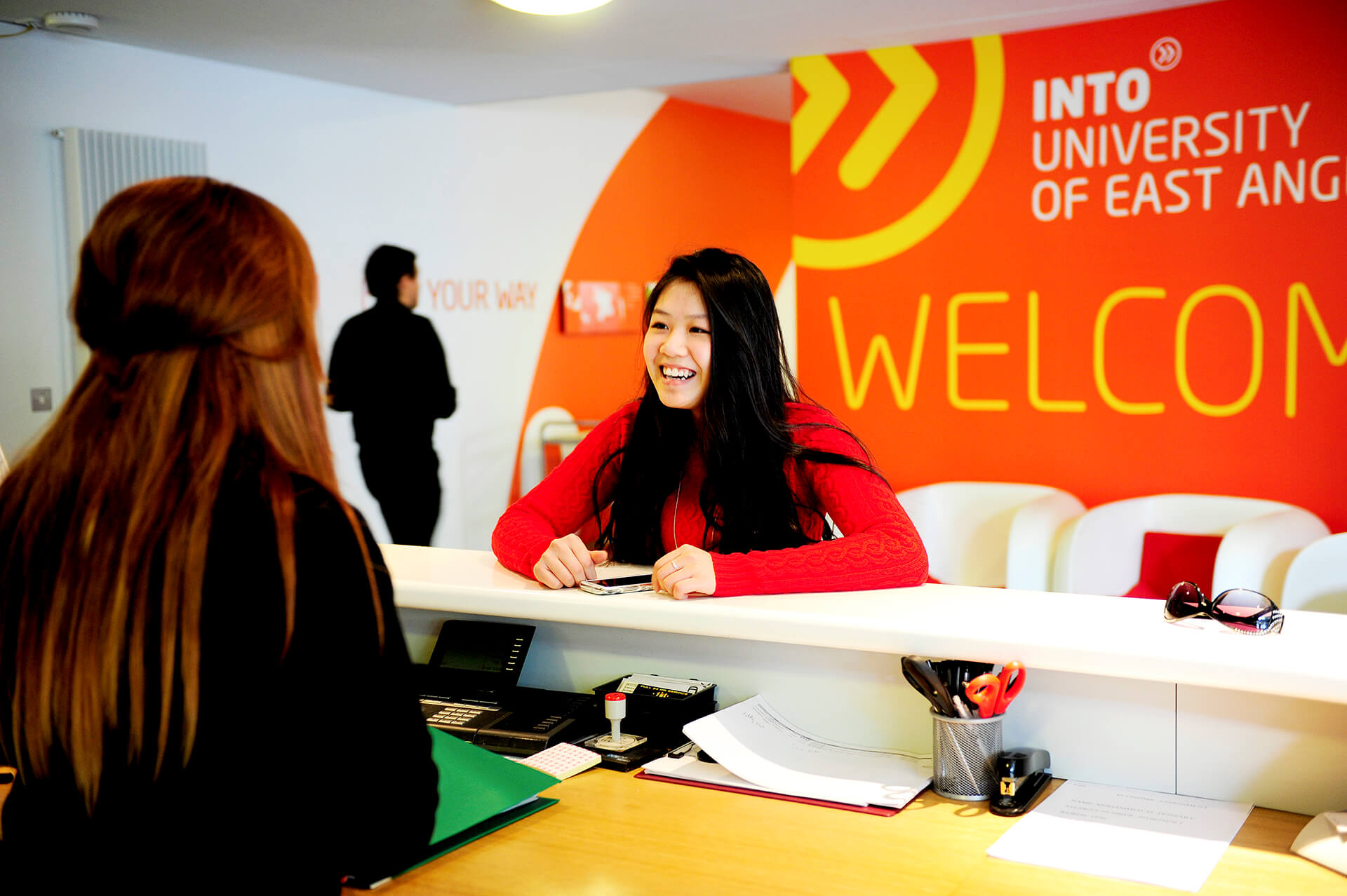 国际学生在INTO中心前台与工作人员交谈