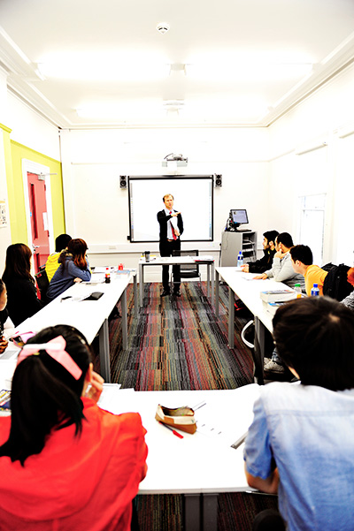 International students in classroom with teacher and white board