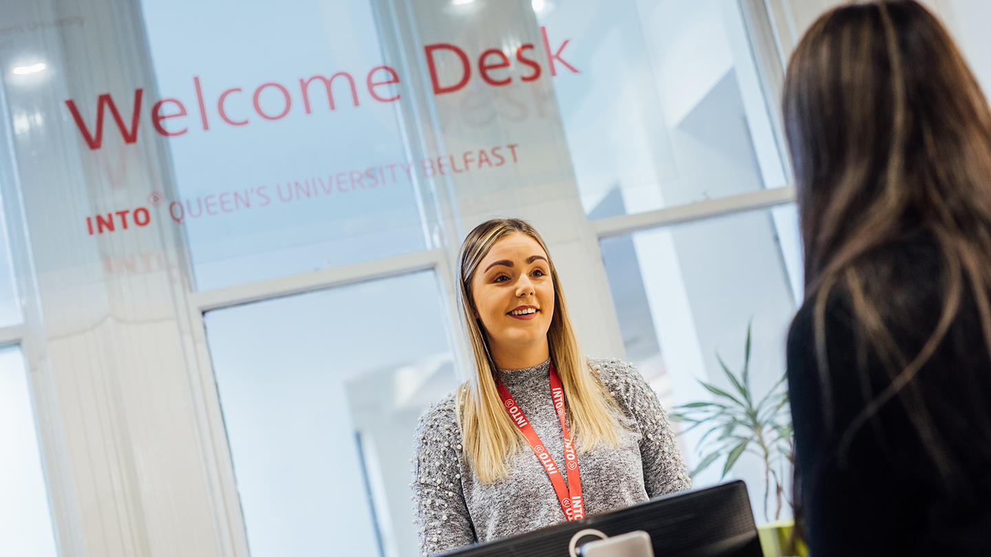 Student talking to a staff member at INTO Queen's University Belfast welcome desk 